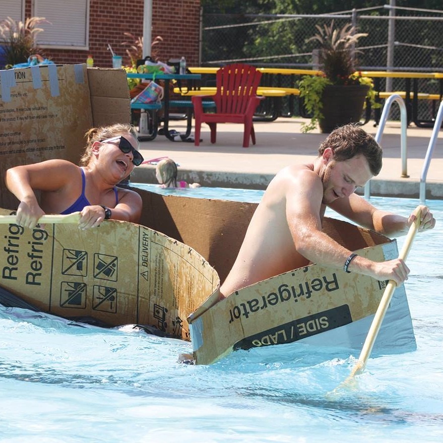 2 people rowing a cardboard boat