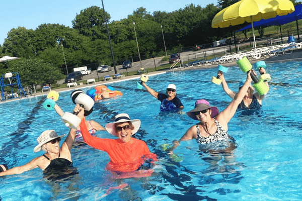 Women enjoying water aerobics class, a low-impact exercise option in JC Parks. 