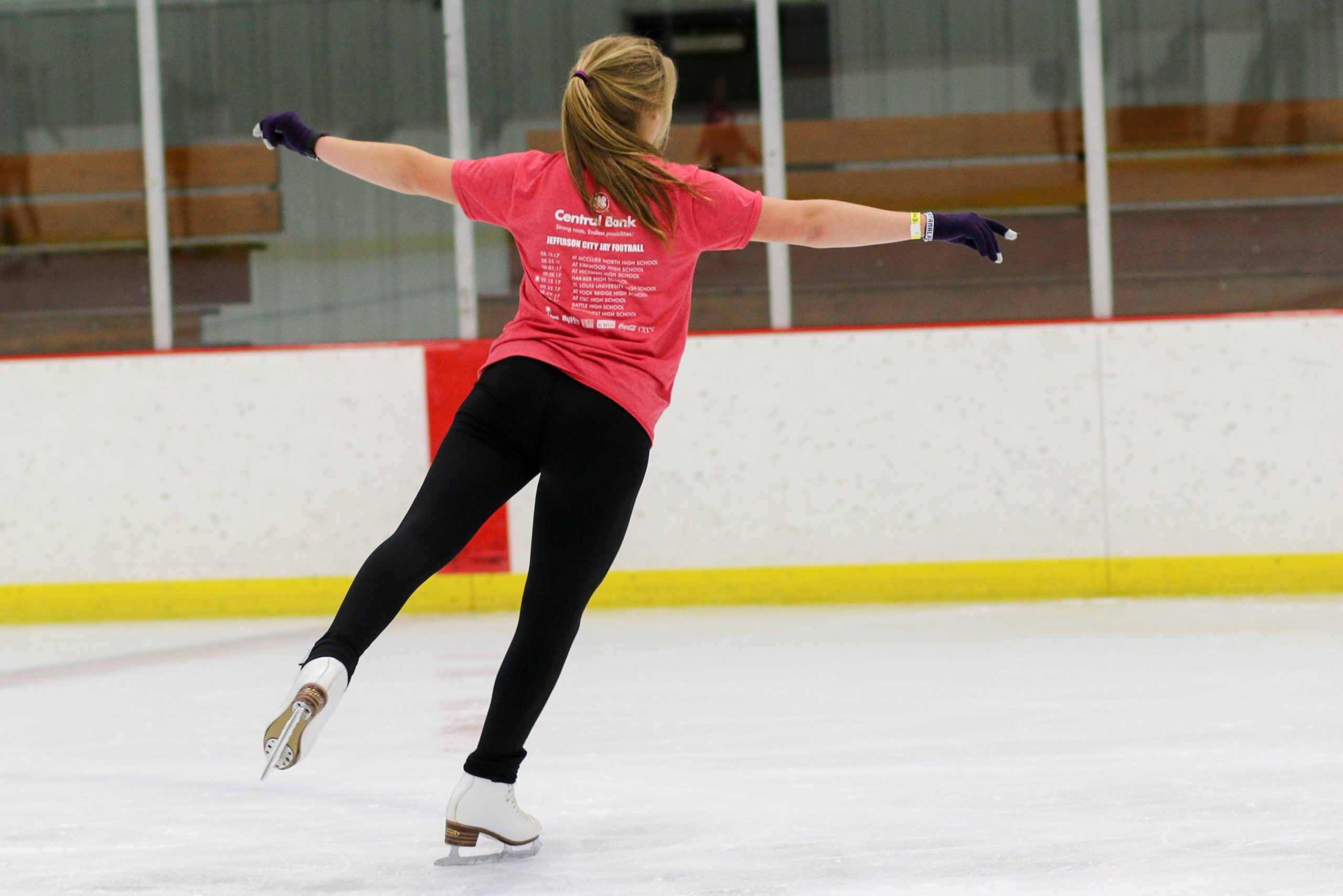 Girl in red t-shirt at figure skating practice.