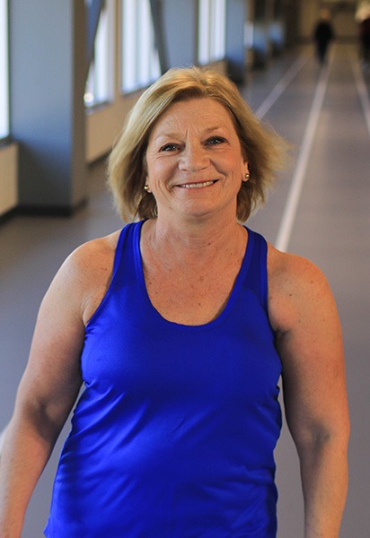 woman-walking woman in a blue tank top exercising on a track